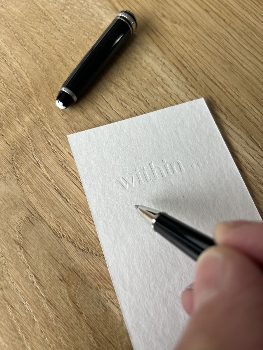 A hand ready to write on a YYU keepsake